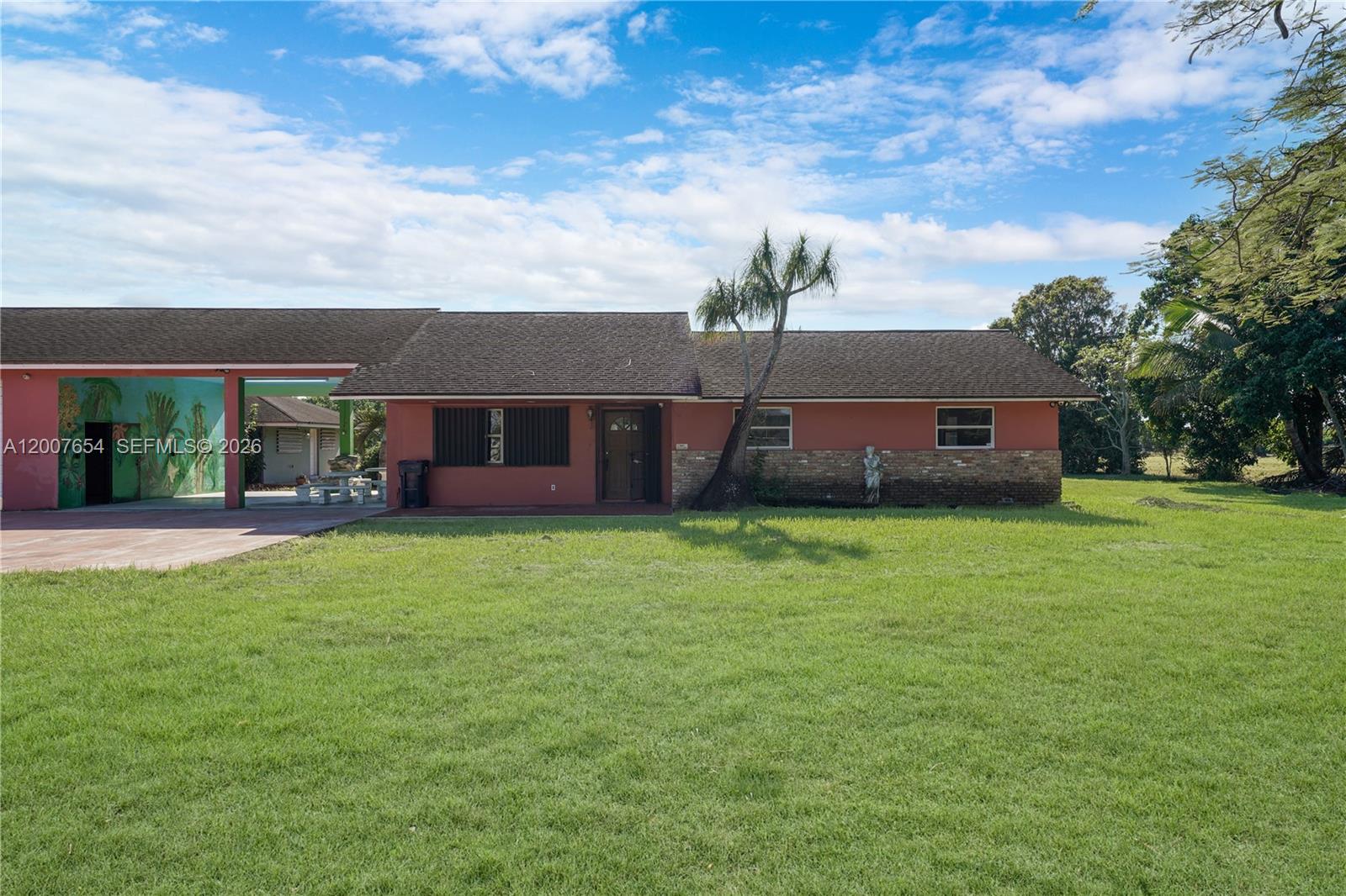 A single-story house with a red exterior, stone accents, and a large attached carport — 20000 SW 216th St, Miami FL 33170, MIAMI, FL