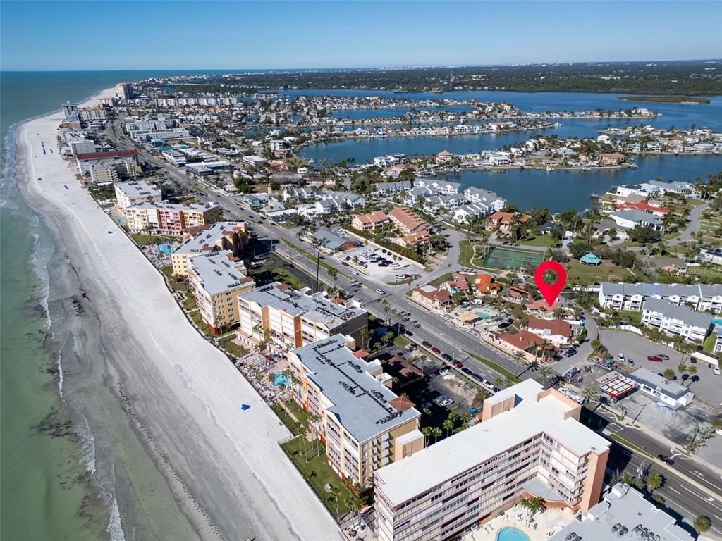 An aerial view shows a beachside resort area with a red location pin — 16613 GULF BOULEVARD, NORTH REDINGTON BEACH, FL