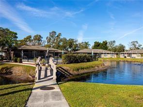 A kitchen features white cabinets, white appliances, tiled floors, and a ceiling fan — 5323 11TH ST CIRCLE E, BRADENTON, FL