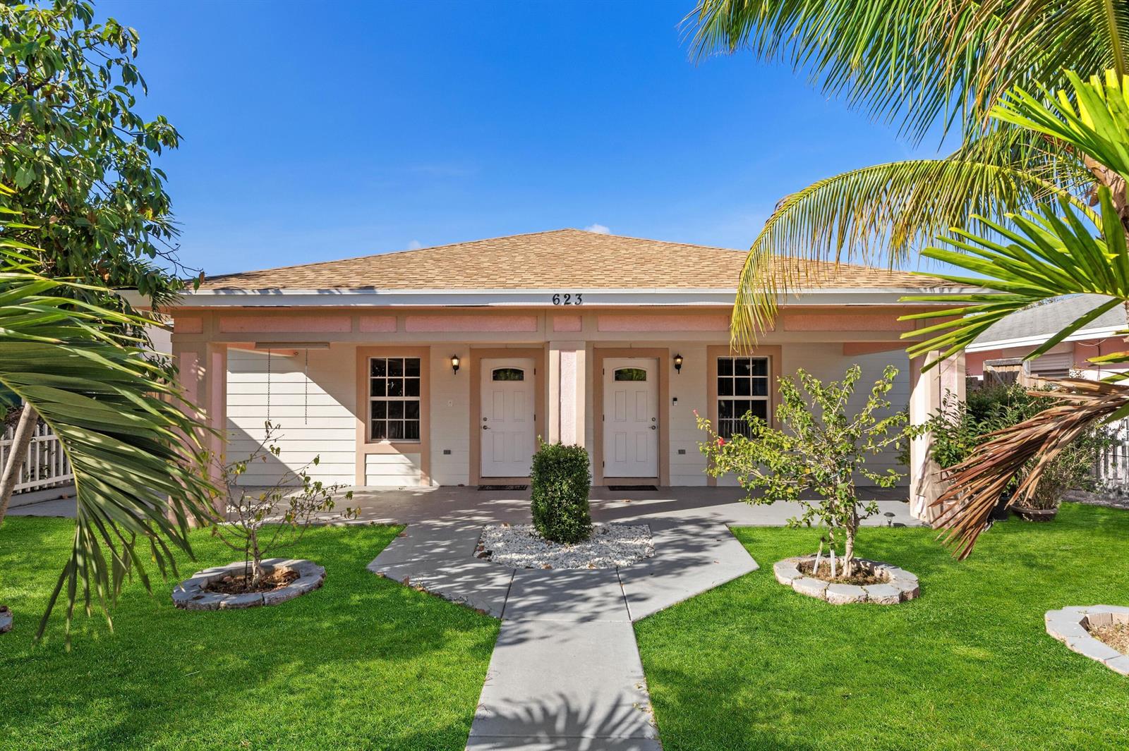 A single-story duplex with a covered porch, two front doors, and a landscaped front yard — 623 N L Street, FL 33460, FL