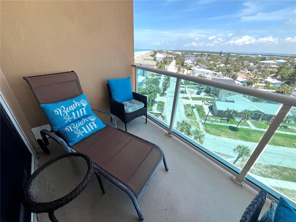 A balcony with a lounge chair, a small table, and a view of the coast — 880 MANDALAY AVENUE UNIT N610, CLEARWATER BEACH, FL