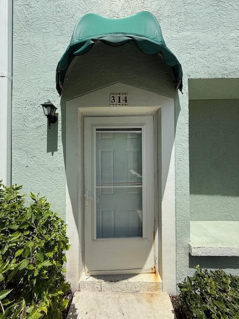 A front door with a green scalloped awning and the number 314 above it — 314 Waterside Drive, Hypoluxo FL 33462, HYPOLUXO, FL