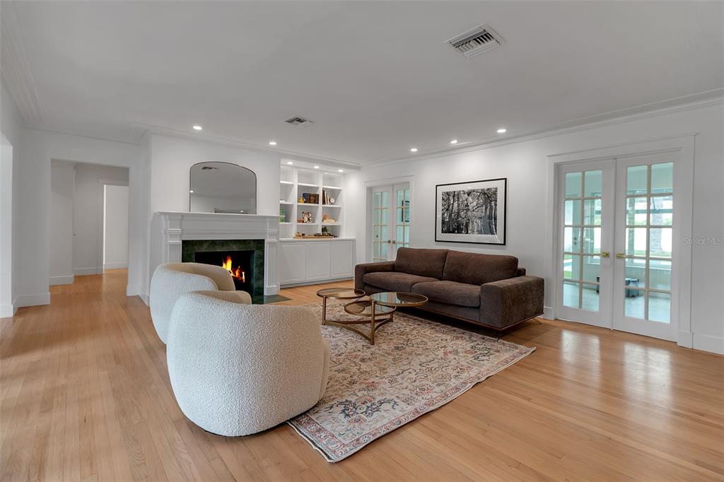 A living room features a fireplace, built-in shelving, a brown sofa, and two white chairs — 1838 ALTA VISTA STREET, SARASOTA, FL