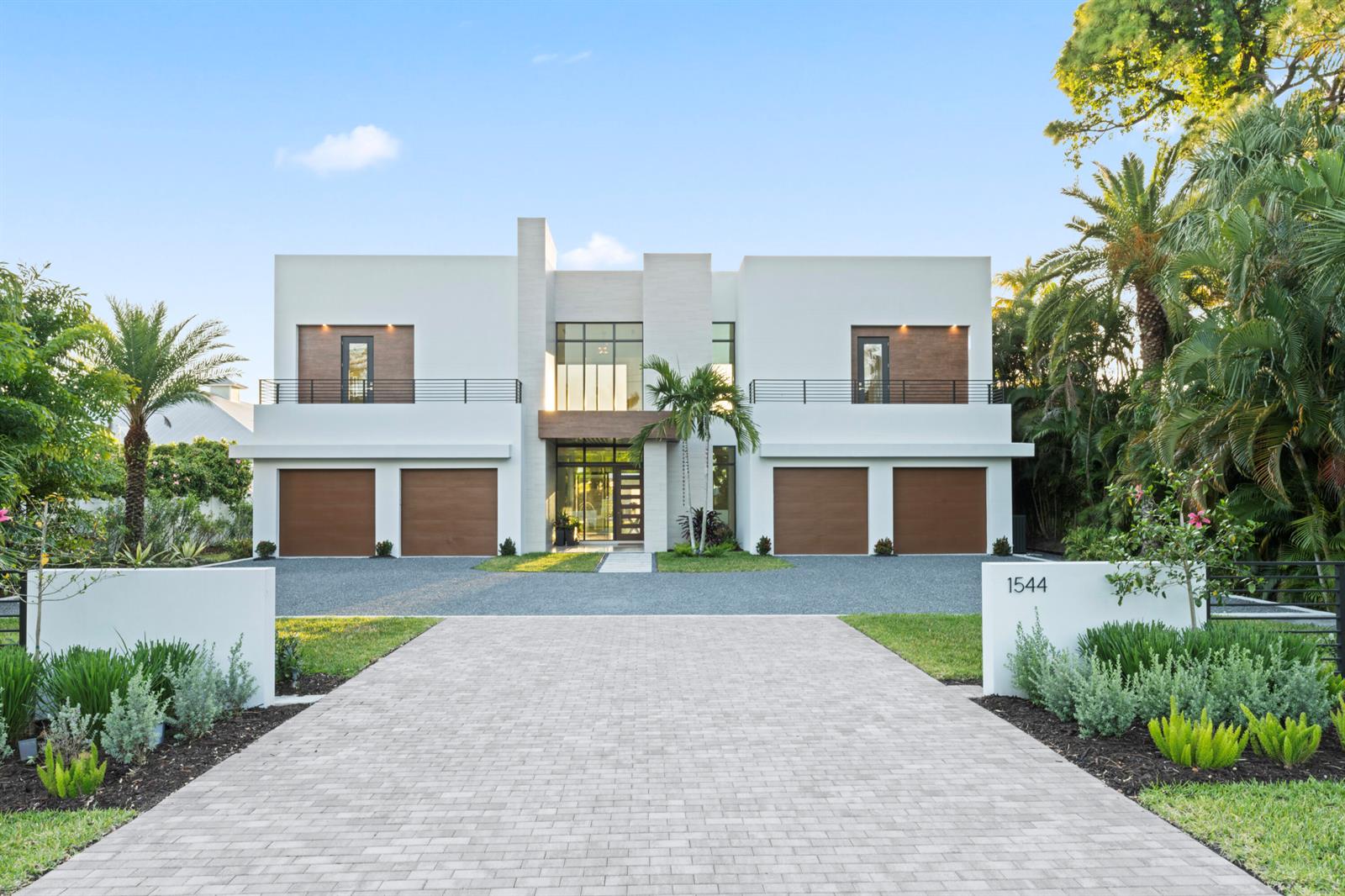 A modern two-story house with four garage doors, a stone driveway, and tropical landscaping — 1544 SE Saint Lucie Boulevard, Stuart FL 34996, STUART, FL