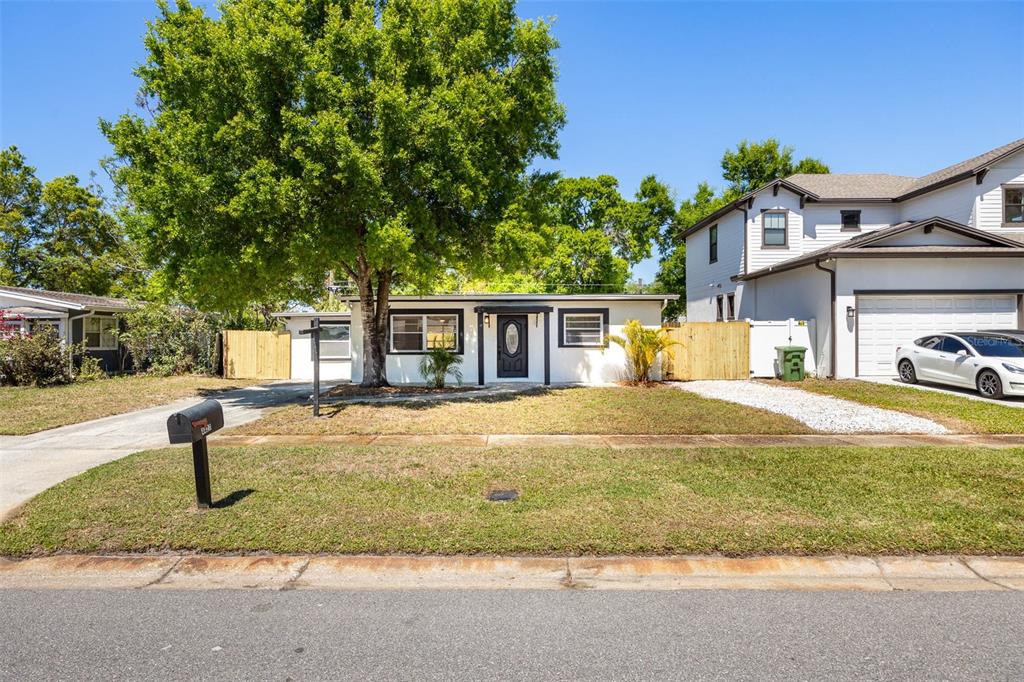 A single-story white house with a large tree in the front yard and a driveway — 4427 W OKLAHOMA AVENUE, TAMPA, FL