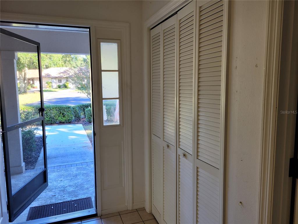 An entryway features a tiled floor, a white louvered closet door, and an open front door — 6018 W BROMLEY CIRCLE, CRYSTAL RIVER, FL