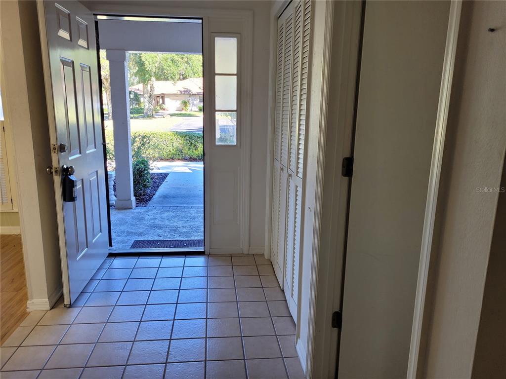 An entryway with tiled flooring, a white front door, and louvered closet doors — 6018 W BROMLEY CIRCLE, CRYSTAL RIVER, FL