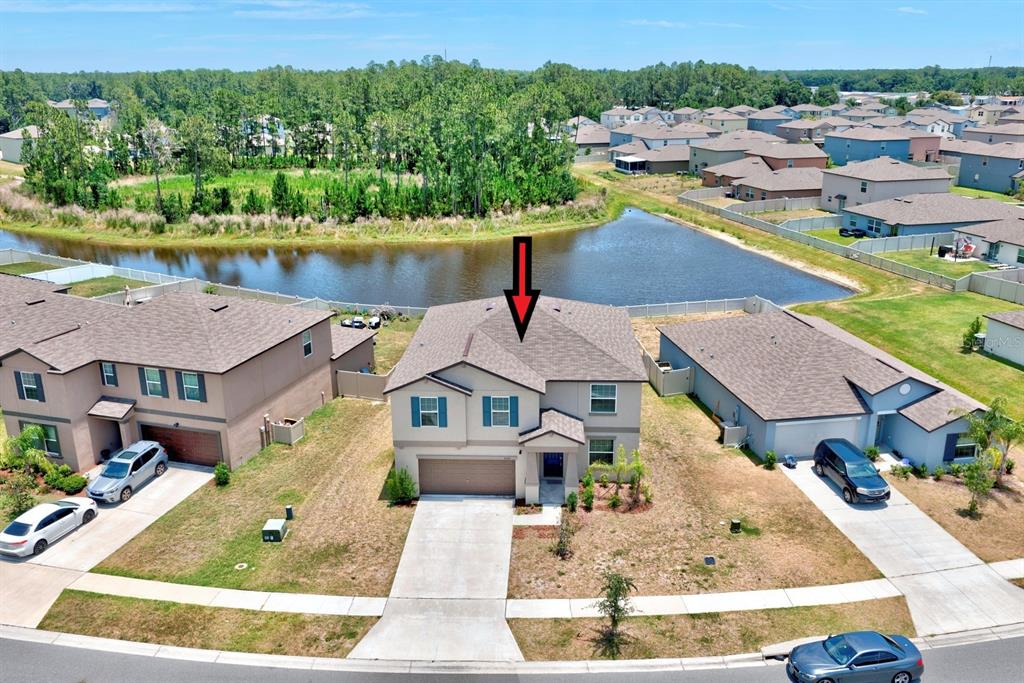 An aerial view shows a two-story suburban house with a driveway and a backyard pond — 2139 OLD MINING ROAD, LAKELAND, FL