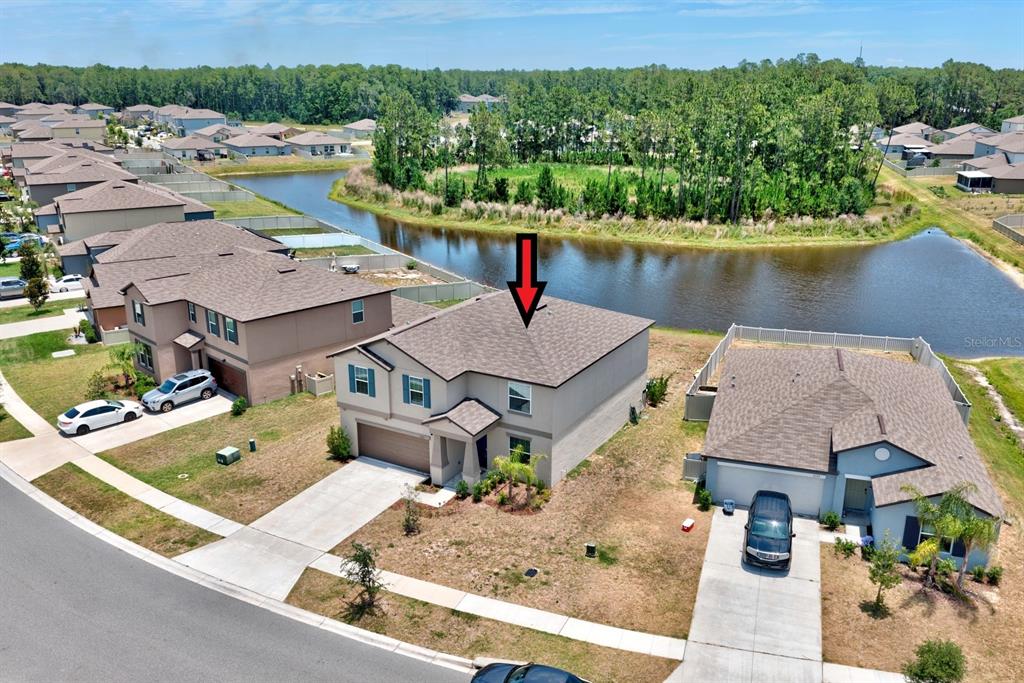 An aerial view shows a two-story suburban house with a red arrow pointing to its roof — 2139 OLD MINING ROAD, LAKELAND, FL