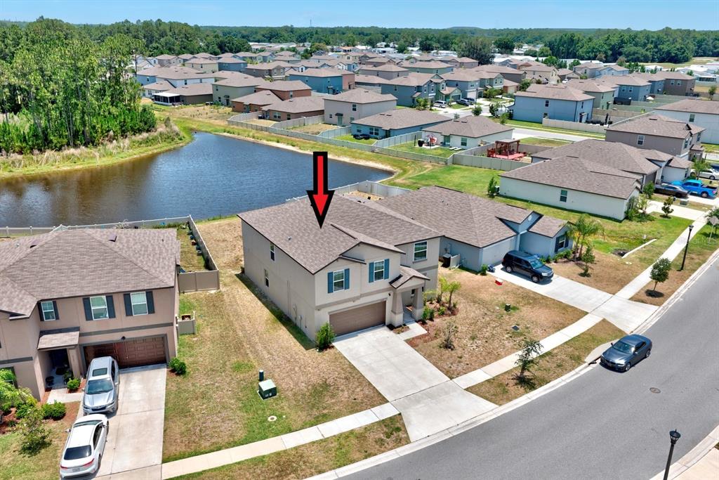 An aerial view shows a two-story suburban house with a garage and a backyard pond — 2139 OLD MINING ROAD, LAKELAND, FL