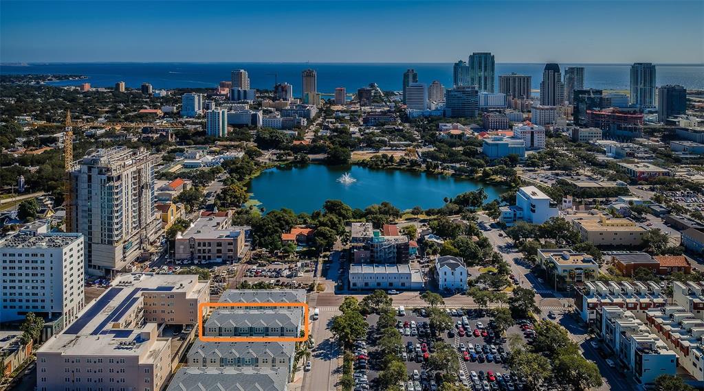 An aerial view shows a multi-story residential building highlighted in orange near a city lake — 815 BURLINGTON AVENUE N, ST PETERSBURG, FL