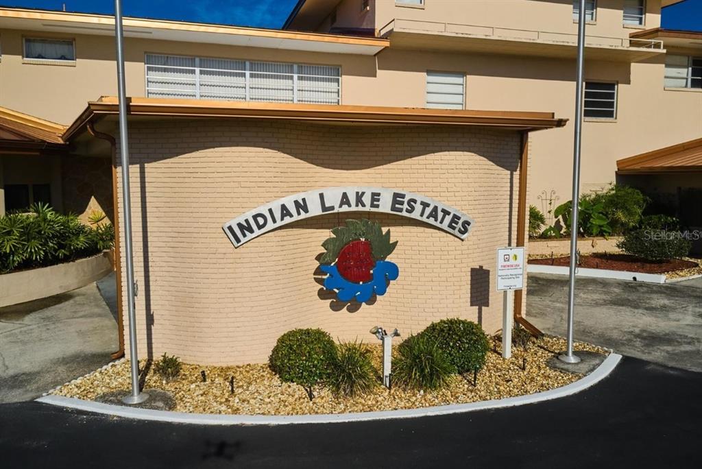 A curved brick wall displays the Indian Lake Estates sign in front of a building — 515 GAILLARDIA DRIVE, INDIAN LAKE ESTATES, FL