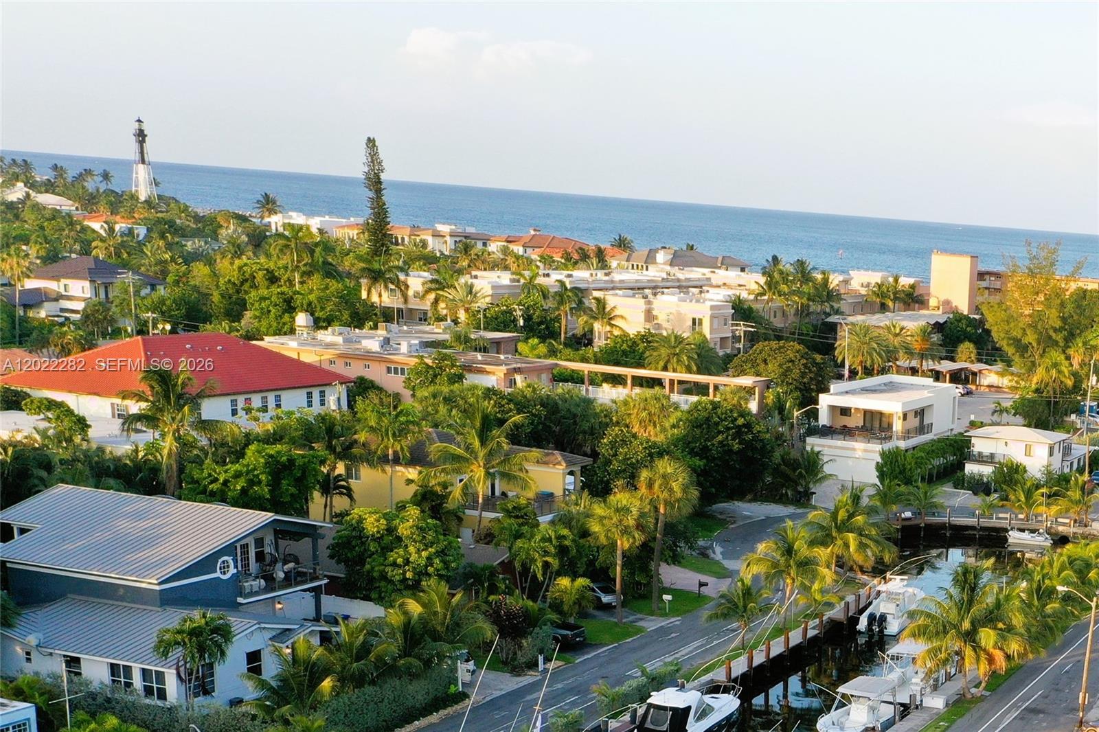 An elevated view shows a coastal neighborhood with houses, palm trees, a canal, and a lighthouse — 3210 Canal Dr # 5, Pompano Beach FL 33062, POMPANO BEACH, FL