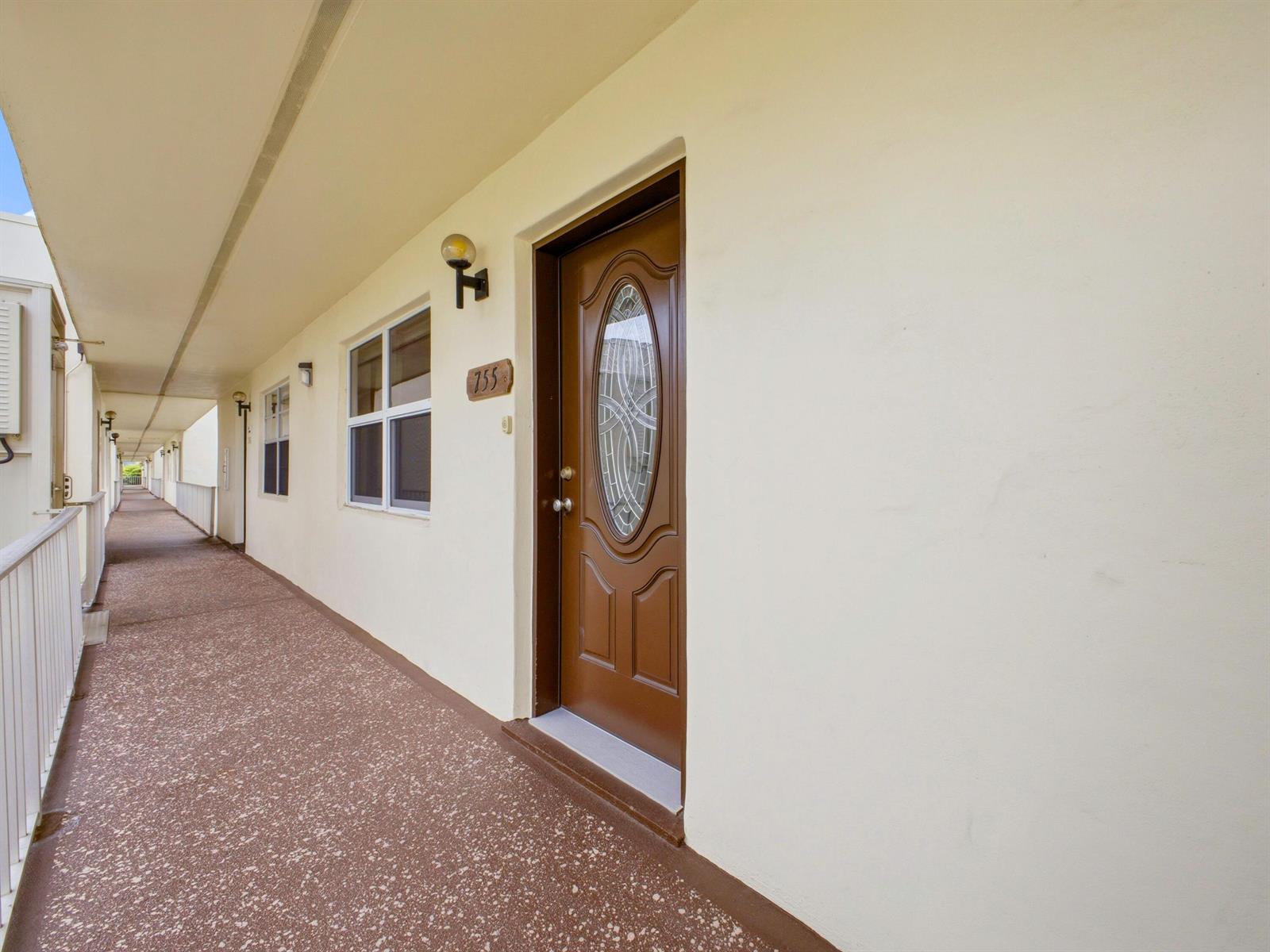 An exterior walkway leads to a brown front door with an oval glass insert — 755 Normandy P, Delray Beach FL 33484, DELRAY BEACH, FL