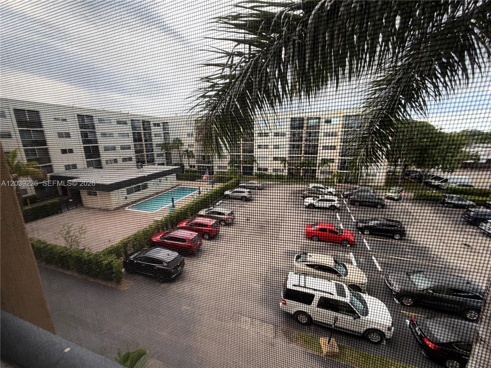An elevated view shows a parking lot and swimming pool between two large apartment buildings — 220 SW 9th Ave # 402, Hallandale Beach FL 33009, HALLANDALE BEACH, FL