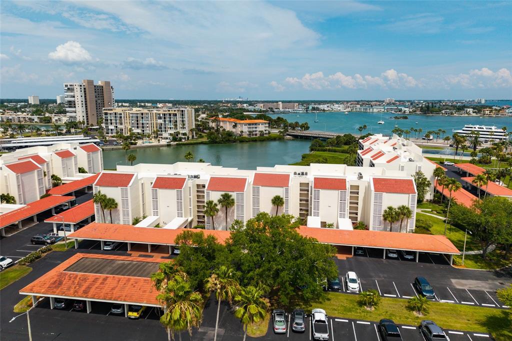An aerial view shows a multi-story residential complex with red-tiled roofs and covered parking — 7897 SAILBOAT KEY BOULEVARD UNIT 107, SOUTH PASADENA, FL