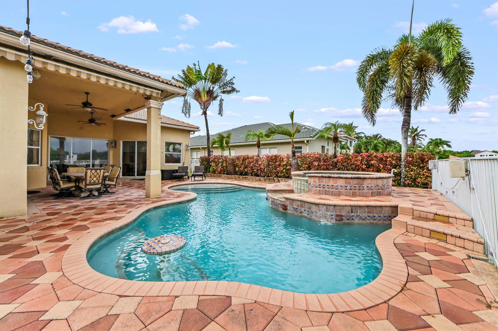 A backyard features a swimming pool with a spa, a patio, and palm trees — 11852 Osprey Point Circle, Wellington FL 33449, WELLINGTON, FL