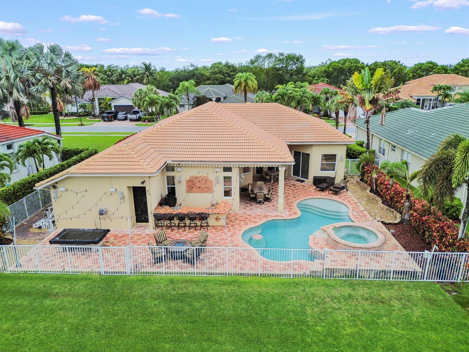 An aerial view of a house exterior featuring a pool, hot tub, and patio area — 11852 Osprey Point Circle, Wellington FL 33449, WELLINGTON, FL