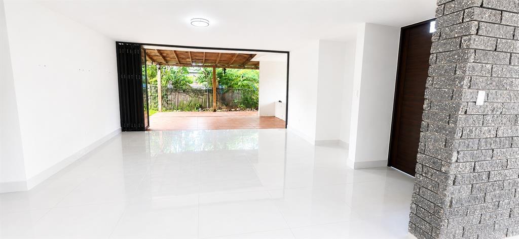 An interior room with white tile floors, a stone pillar, and folding doors to a patio — Urb Parkville AVE. LOPATEGUI, GUAYNABO, PR