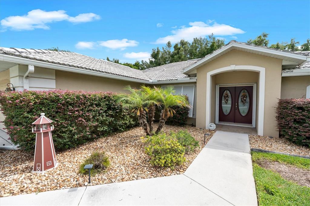 A swimming pool sits in front of a covered patio with a bar and seating — 8388 OMAHA CIRCLE, SPRING HILL, FL