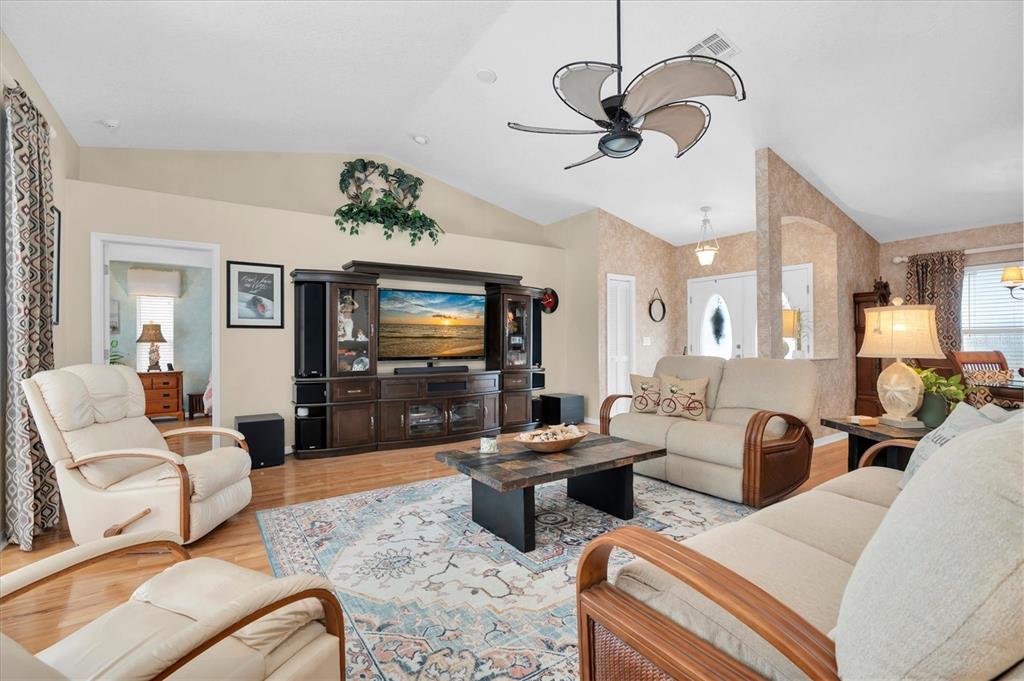 A dining nook features a glass-topped wicker table, tile flooring, and windows with blue valances — 8388 OMAHA CIRCLE, SPRING HILL, FL