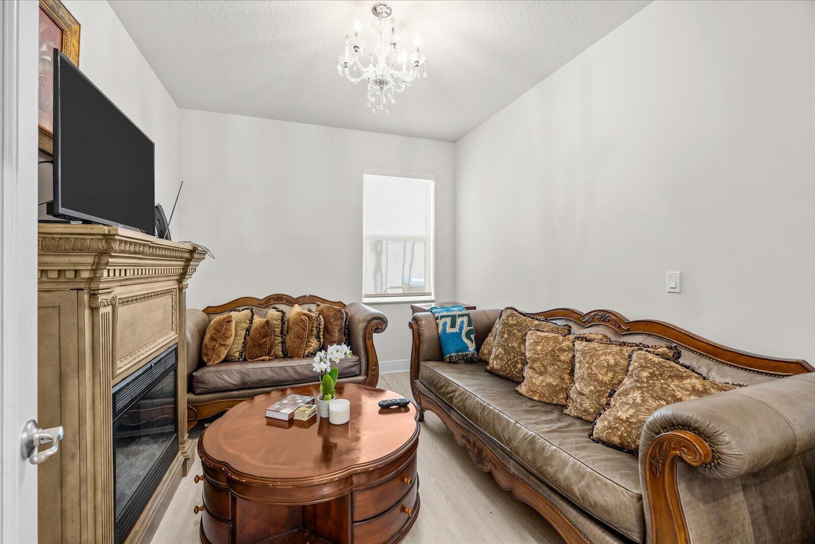 A living room features two ornate brown sofas, a wooden coffee table, and a fireplace — PORT ST. LUCIE, FL