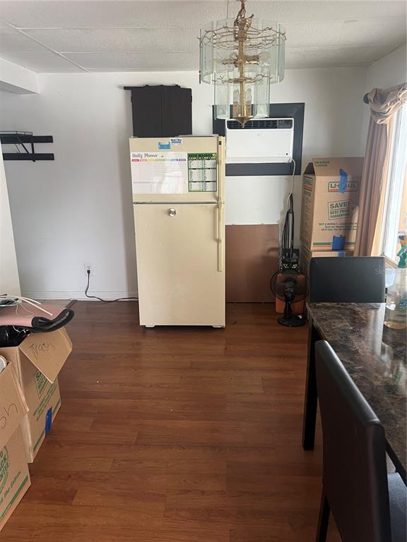 A dining area features wood-look flooring, a refrigerator, a window air conditioner, and a chandelier — 4772 67TH WAY N UNIT 51, ST PETERSBURG, FL