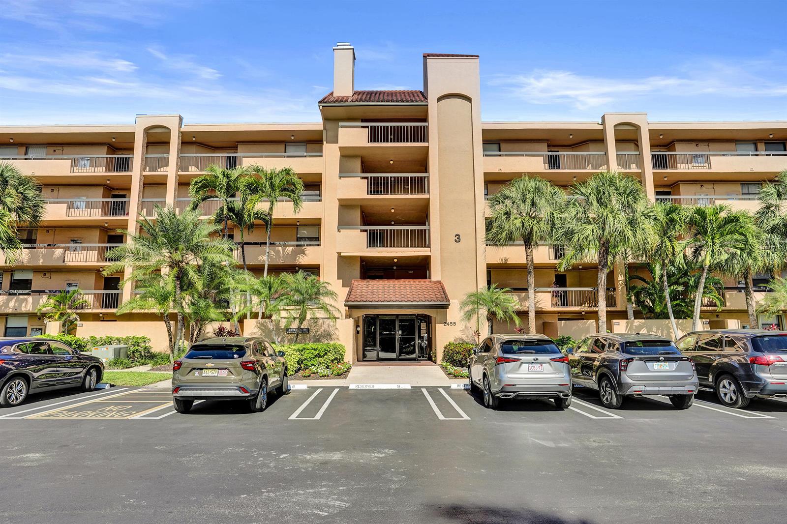 A multi-story apartment building with a central entrance and parking lot in front — 2455 Lindell Boulevard # 3305, Delray Beach FL 33444, DELRAY BEACH, FL