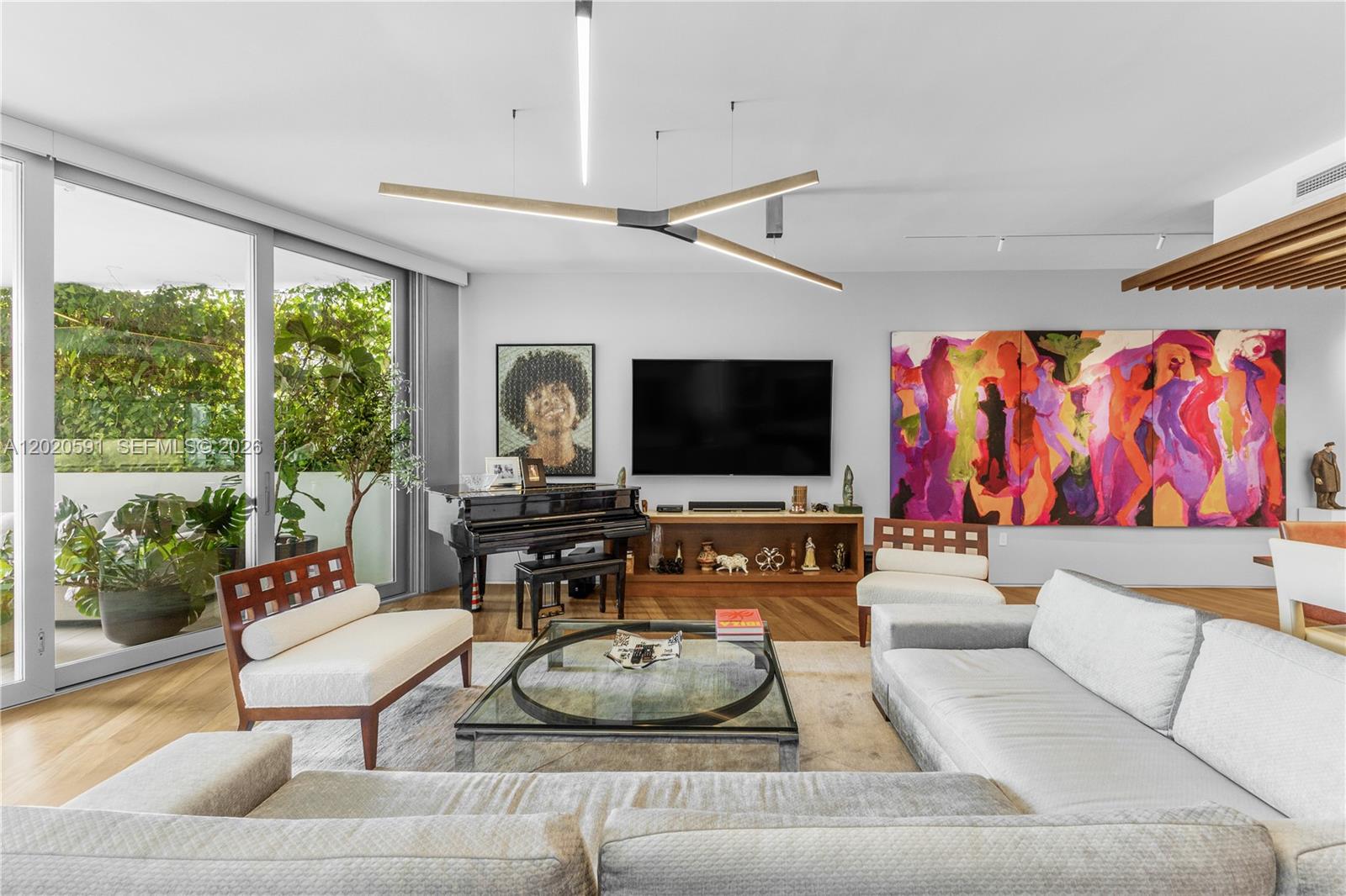 A living room features a grand piano, large abstract painting, and floor-to-ceiling glass sliding doors — 1300 Monad Ter # 3E, Miami Beach FL 33139, MIAMI BEACH, FL