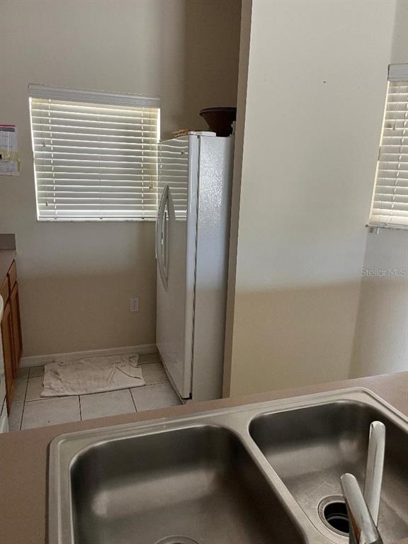 A kitchen features a double-basin sink, a white refrigerator, and windows with blinds — 4529 ALBERTO CIRCLE, KISSIMMEE, FL