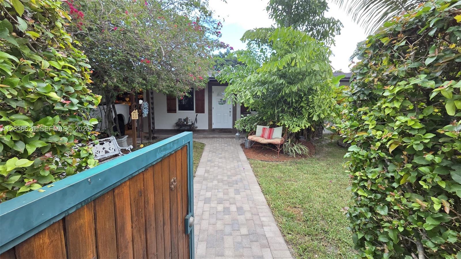 A paved walkway leads to the front door of a house framed by lush landscaping — 3511 SW 105th ct, Miami FL 33165, MIAMI, FL