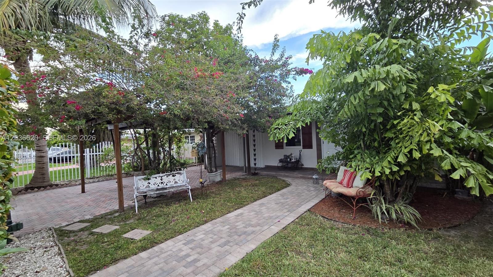 A paved walkway leads to a house entrance shaded by a large flowering tree — 3511 SW 105th ct, Miami FL 33165, MIAMI, FL