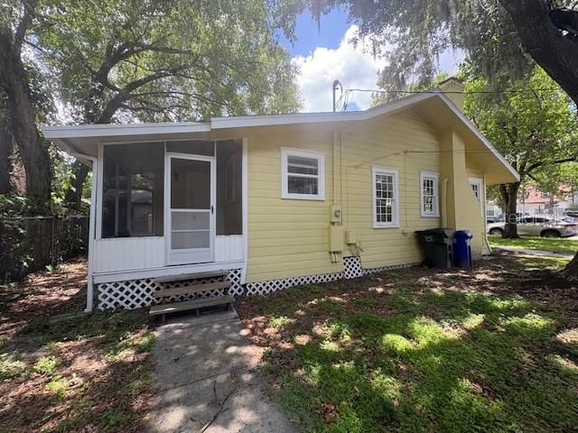 A yellow house with a screened-in porch and a small wooden staircase — 714 WINFREE AVENUE, LAKELAND, FL