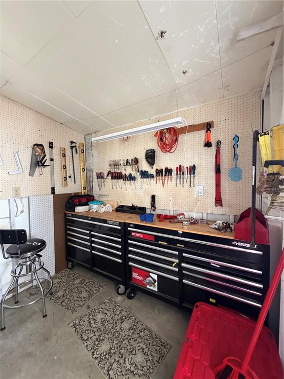 A garage workshop features a workbench with black tool chests and a pegboard tool wall — 520 MARNIE CIRCLE, MELBOURNE, FL