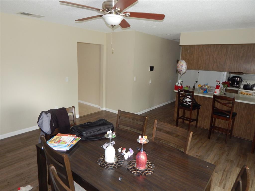 A dining area with a wooden table and chairs sits adjacent to a kitchen counter — 3509 LISA LANE, LAKELAND, FL