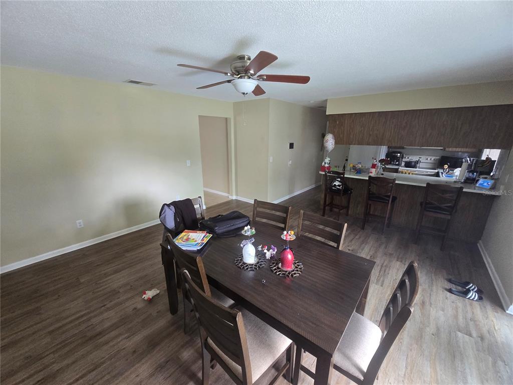 A dining area with a dark wood table and chairs sits adjacent to a kitchen counter — 3509 LISA LANE, LAKELAND, FL