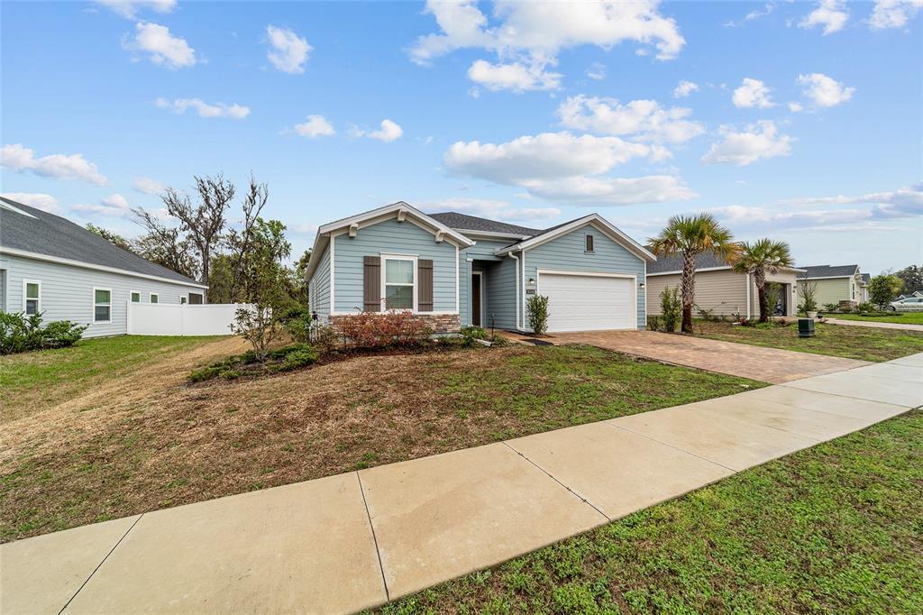 A light blue single-story house with a two-car garage and a paved driveway — 1830 NW 44TH COURT ROAD, OCALA, FL