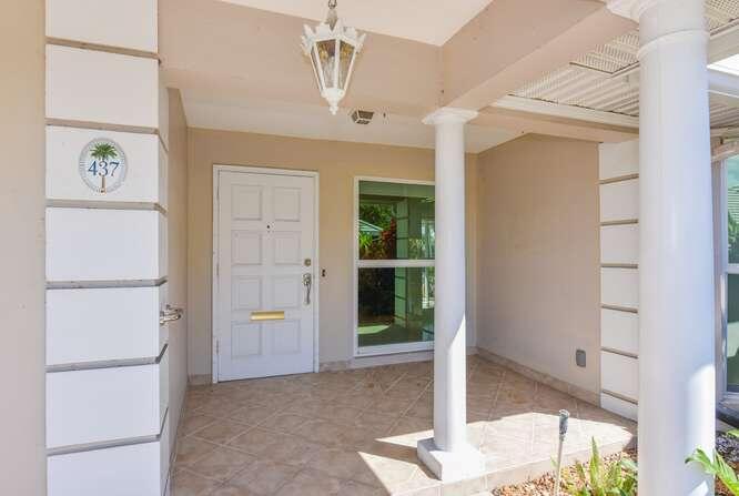 A covered entryway features a white door, tiled flooring, and two white columns — 437 French Royale Circle, Atlantis FL 33462, ATLANTIS, FL