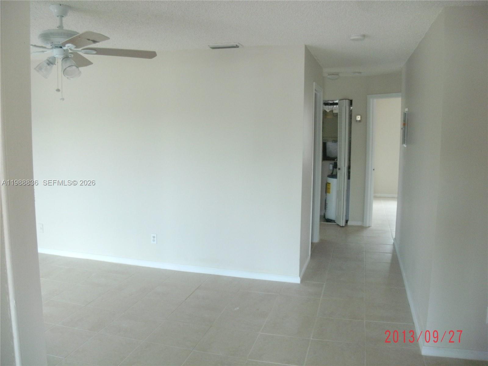 A room with a ceiling fan and tiled flooring leads to a hallway with closets — 1409 Lake Ave # 5, Lake Worth FL 33460, LAKE WORTH, FL
