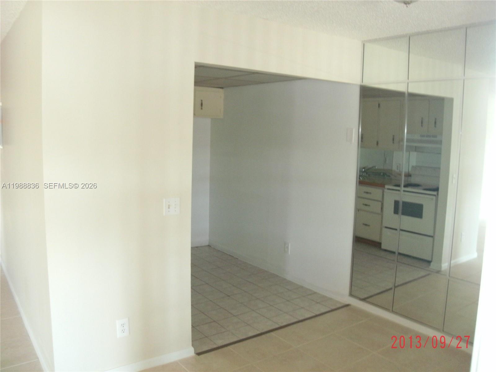 A view of a kitchen area with tiled floors and a mirrored wall panel — 1409 Lake Ave # 5, Lake Worth FL 33460, LAKE WORTH, FL