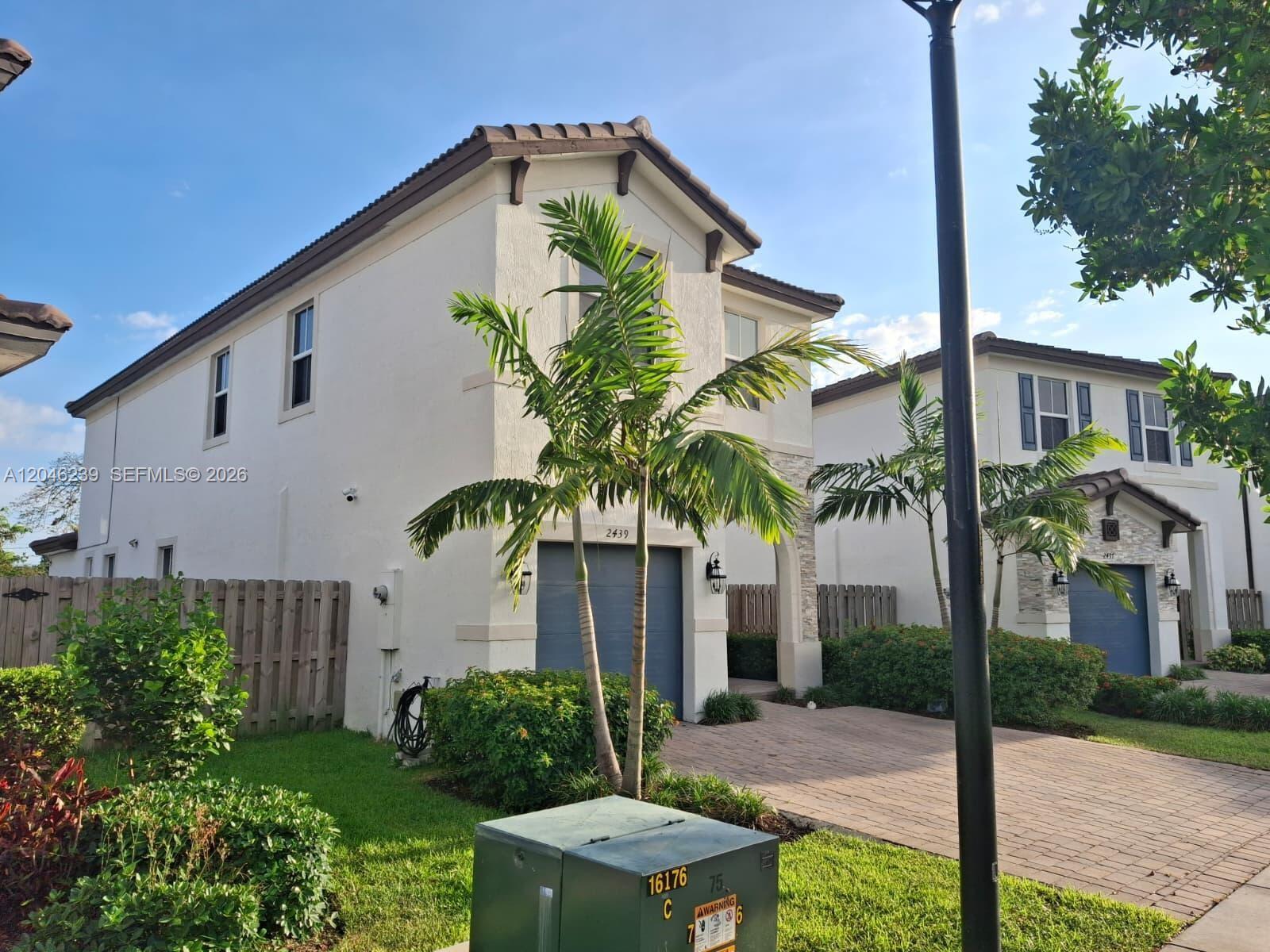A two-story stucco house with a garage, palm trees, and a paved driveway — 2439 NW 131st Cir, Miami FL 33167, MIAMI, FL