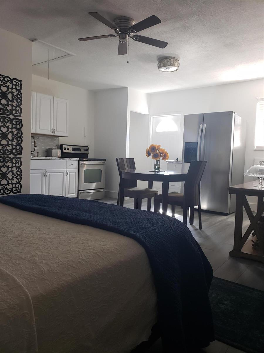 A studio apartment featuring a kitchen with white cabinets, stainless appliances, and a dining area — 14313 N Flora Lane # A, Wellington FL 33414, WELLINGTON, FL