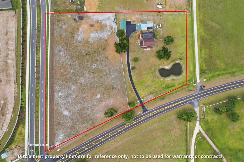 An aerial view shows a house with a pool and pond on a large lot — 15470 STATE ROAD 62, PARRISH, FL