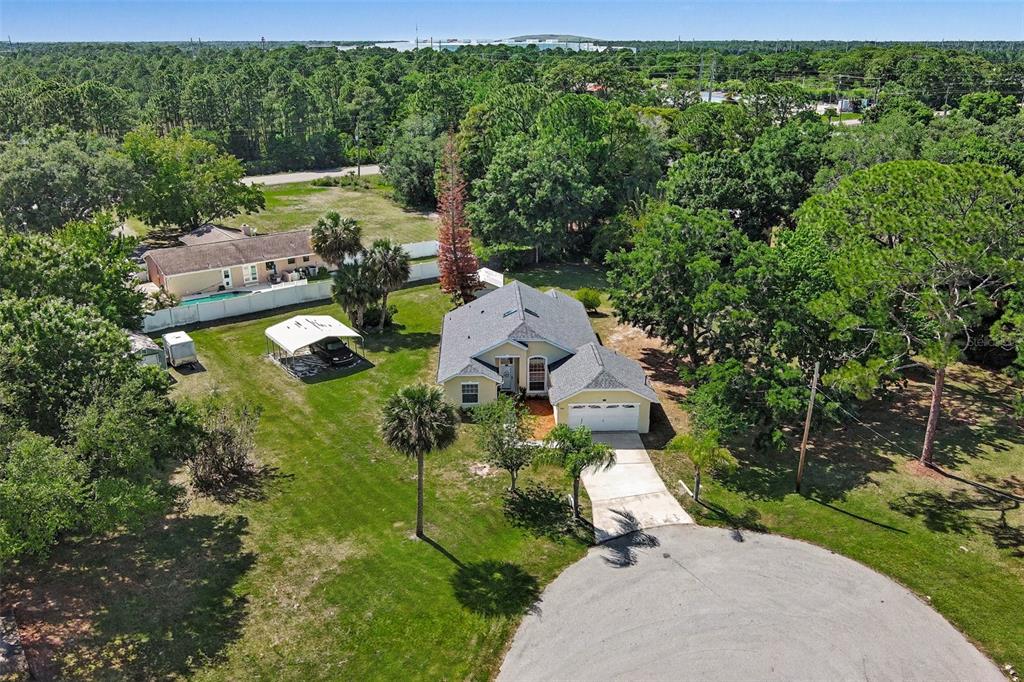 An aerial view shows a yellow house with a gray roof and a large yard — 760 MONDAY COURT, COCOA, FL