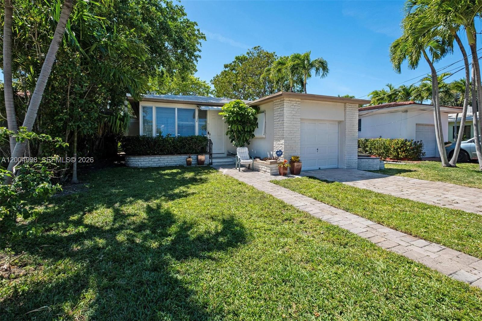 A single-story house with a white brick facade, a garage, and a paved walkway — 9516 Byron Ave, Surfside FL 33154, SURFSIDE, FL