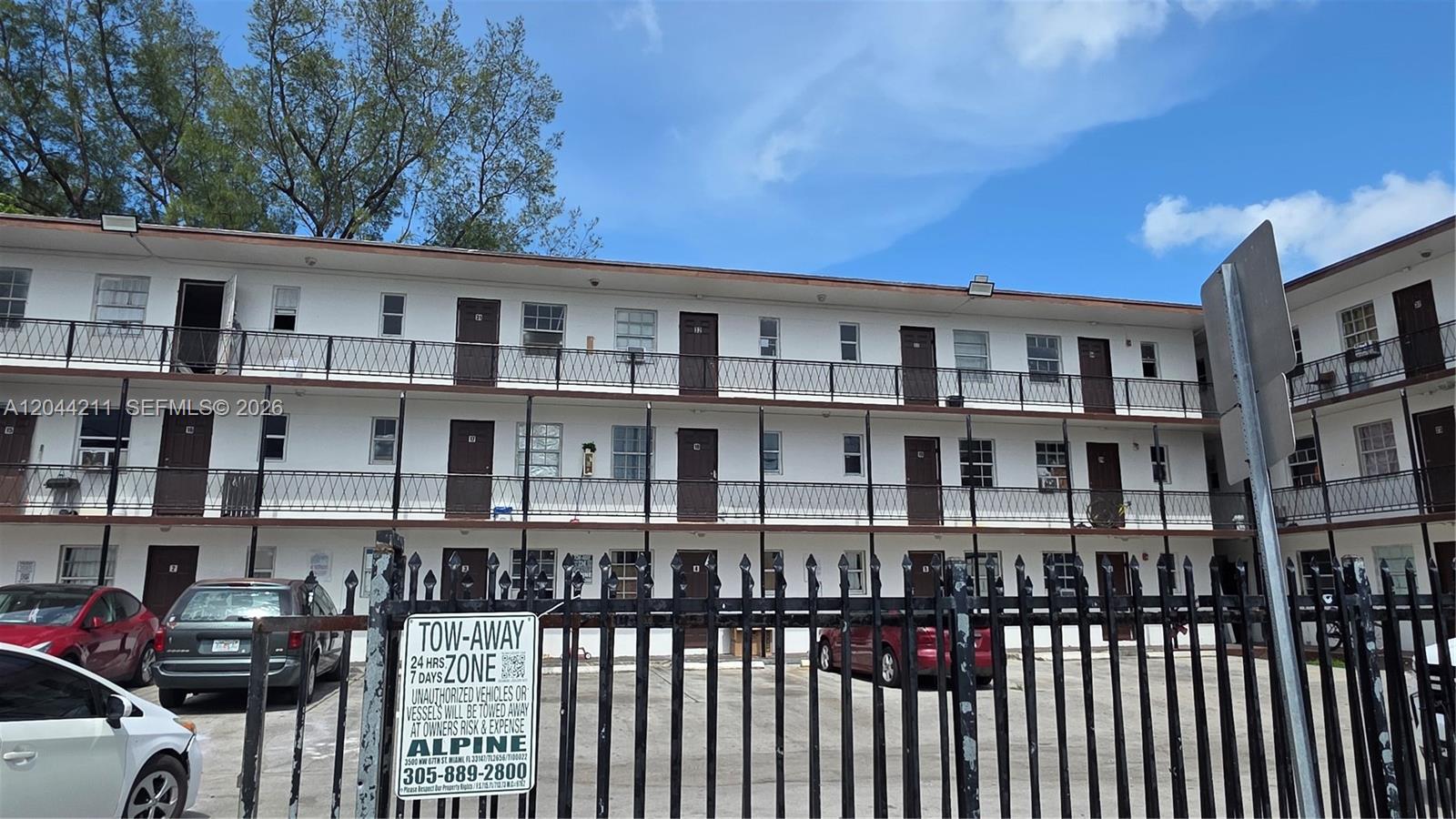 A three-story apartment building with exterior walkways and a black metal fence in front — 7001 NW 15th Ave # 8, Miami FL 33147, MIAMI, FL
