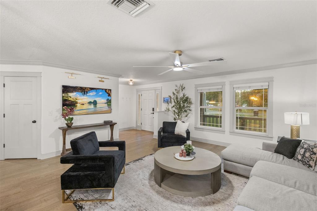 A living room features a light gray sectional, two black armchairs, and a round coffee table — 6109 N 22ND STREET, TAMPA, FL