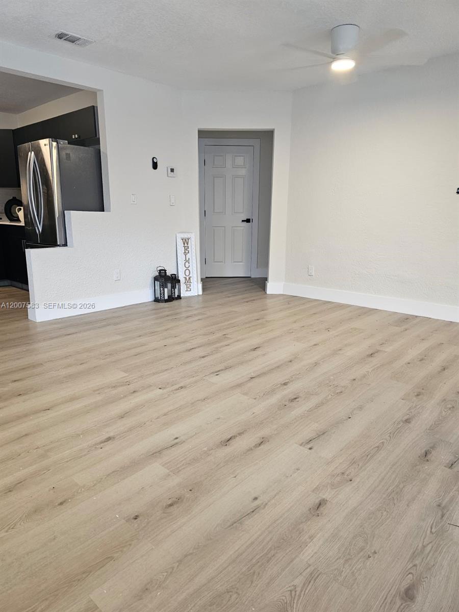 A room with light wood-look flooring, a ceiling fan, and a white door — 1865 NW 45th St # 1, Miami FL 33142, MIAMI, FL