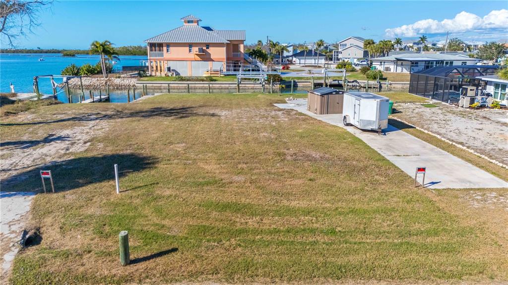 A vacant waterfront lot features a concrete driveway, a small shed, and a utility trailer — 1908 MICHIGAN AVENUE, ENGLEWOOD, FL