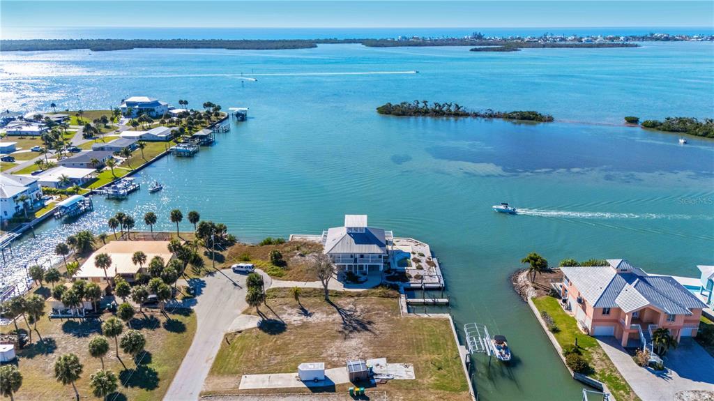 An aerial view shows waterfront homes, a canal, and boats on a sunny day — 1908 MICHIGAN AVENUE, ENGLEWOOD, FL